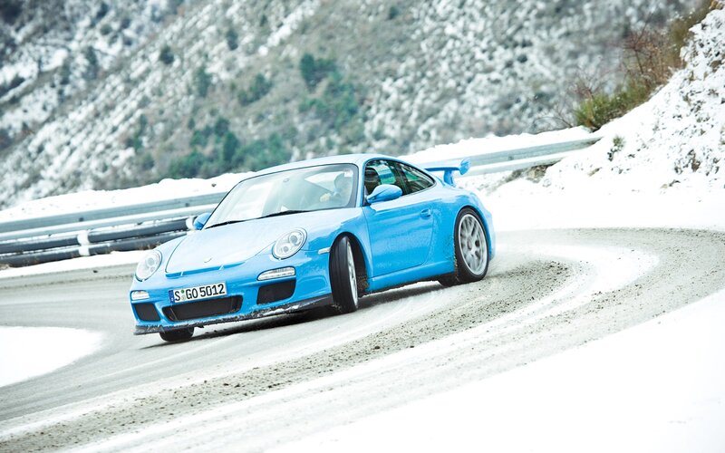 Blue Porsche on snowy road