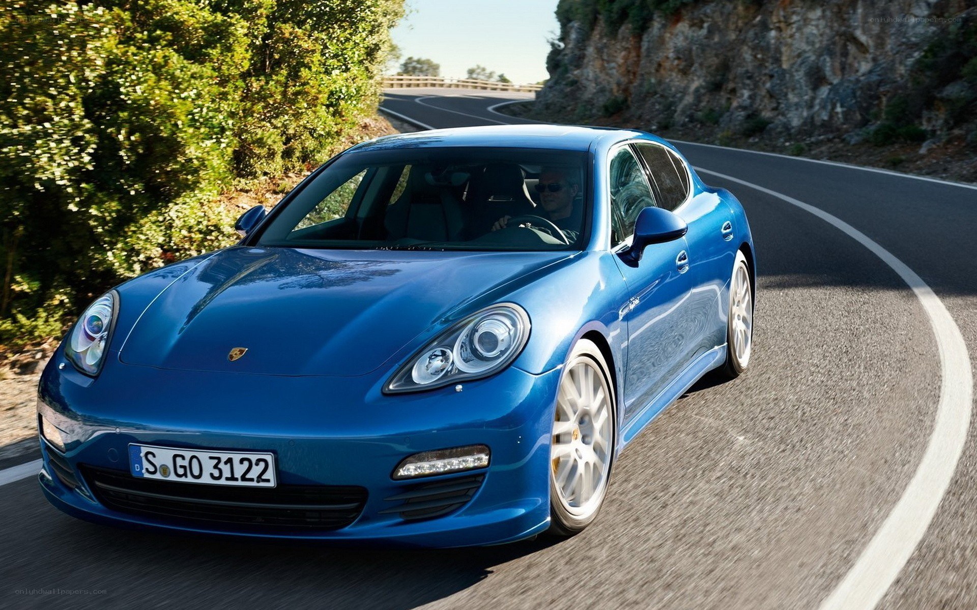 Blue Porsche on winding road