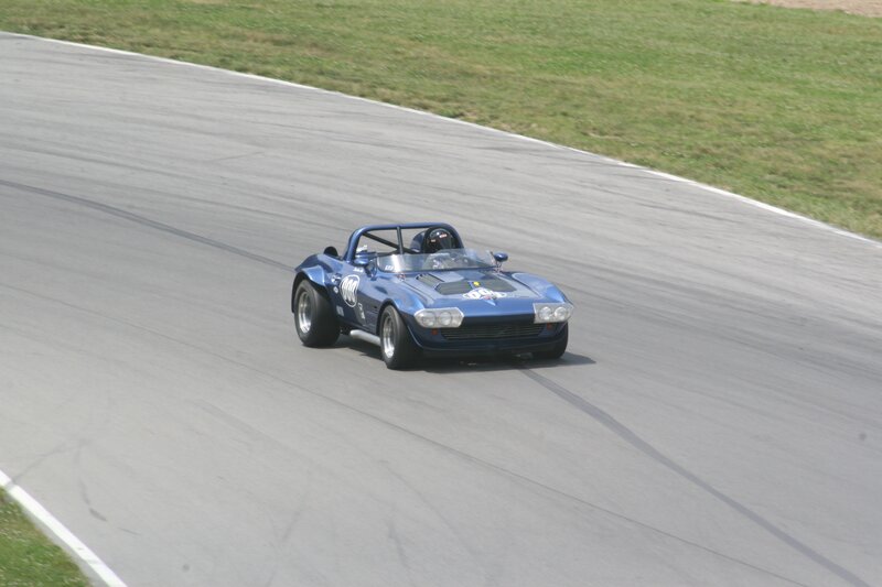 Blue Race Car on Track — Dynamic, Afternoon, Photograph, Driver, Race Track, Grass, Gray