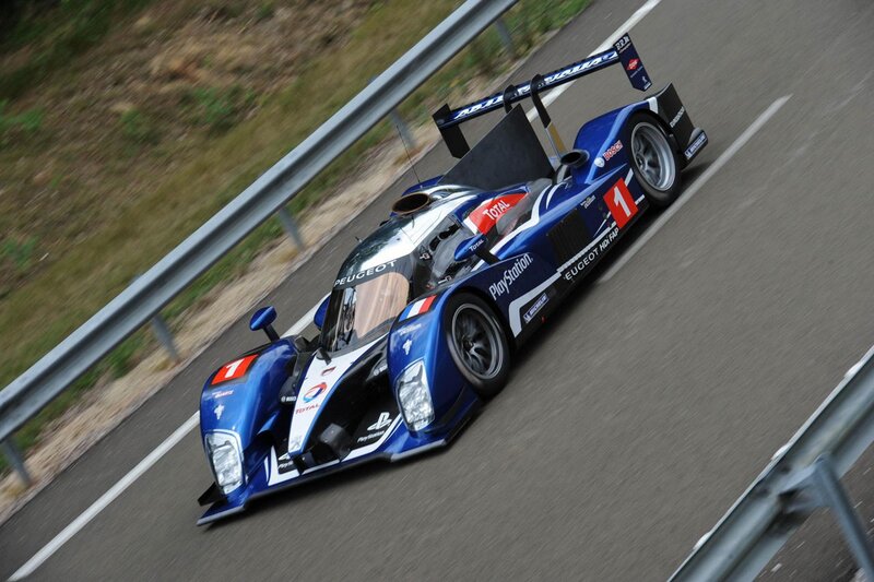 Blue Race Car on Track — Dynamic, Photograph, Race Car, Guardrail, Road
