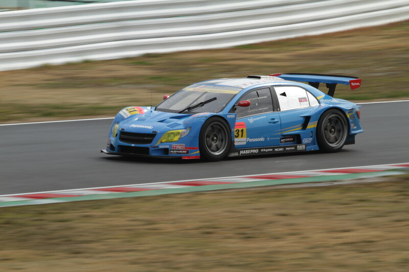 Blue Race Car on Track — Dynamic, Photograph, Race Car, Guardrail