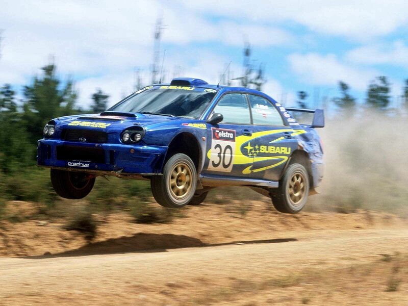 Blue rally car in mid-air