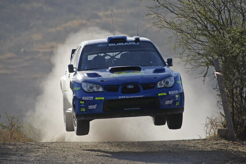 blue rally car in mid-air