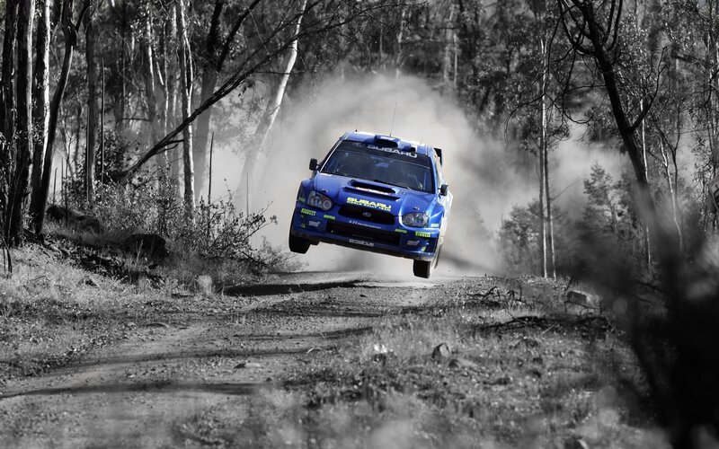 Blue rally car in mid-air