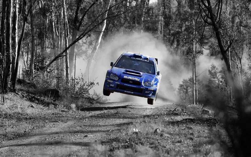 Blue rally car in mid-air