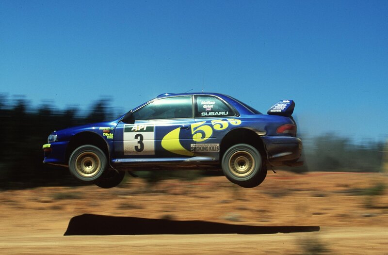 Blue rally car in mid-air jump