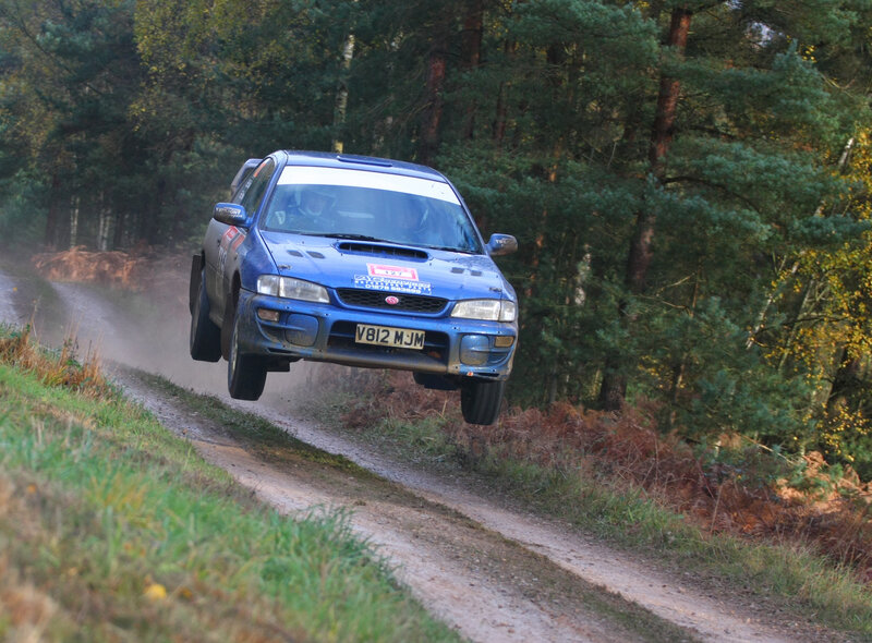 Blue rally car in mid-air jump