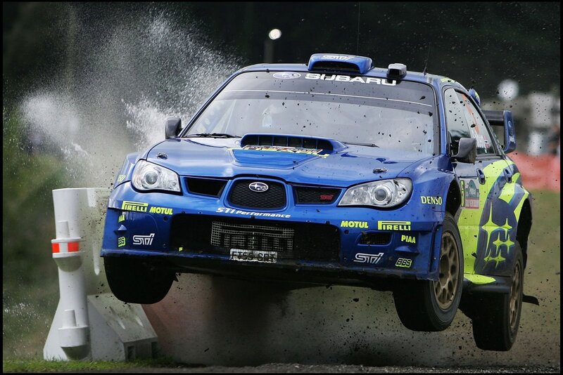 Blue rally car in mid-air jump