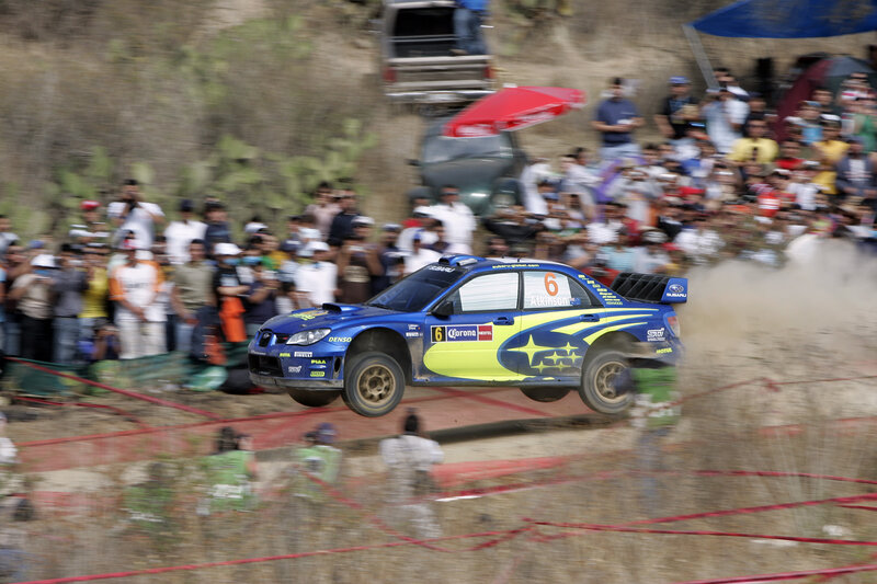 Blue rally car in mid-air jump