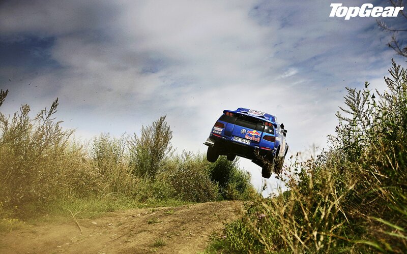 Blue rally car in mid-air jump