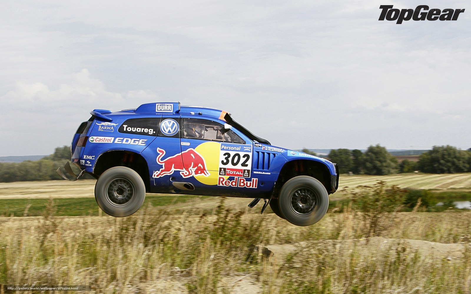 Blue rally car in mid-air jump