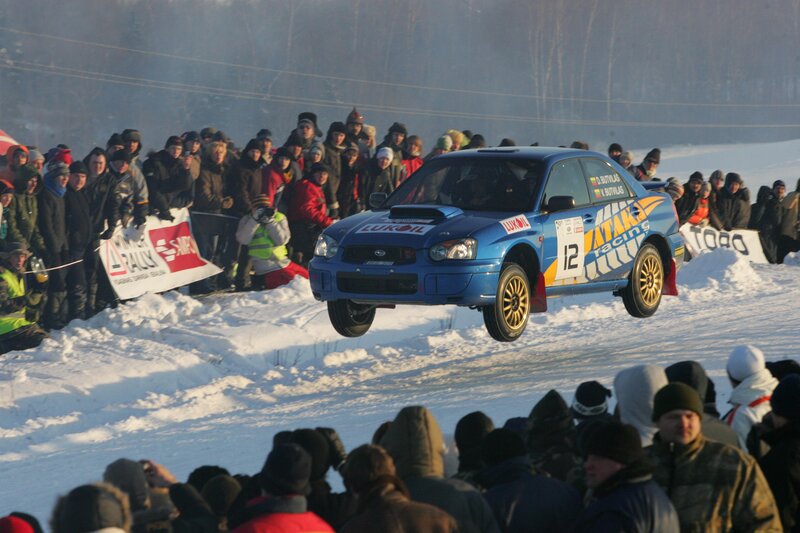 Blue rally car in mid-air jump