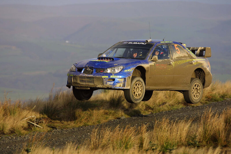Blue rally car in mid-air jump