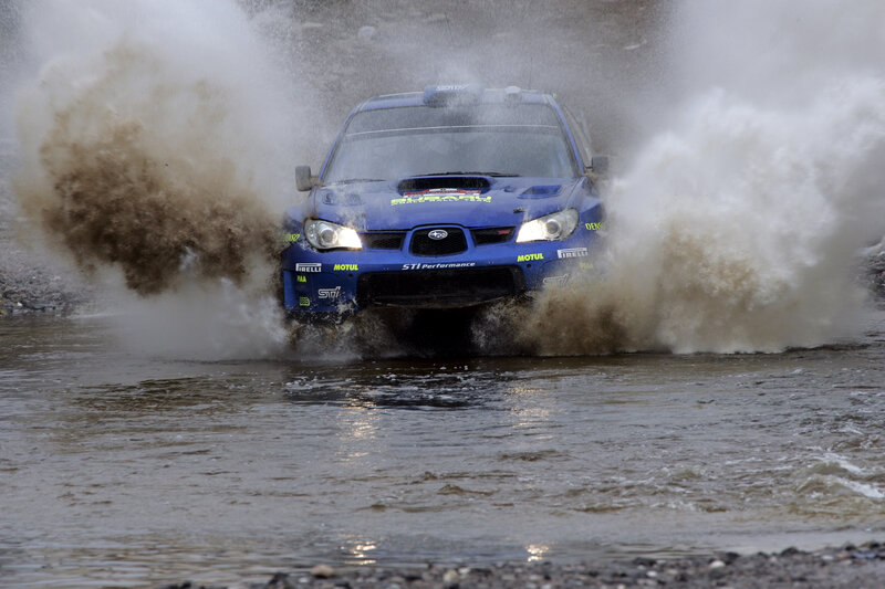 Blue rally car in water splash