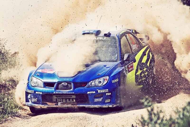 Blue rally car kicking up dust