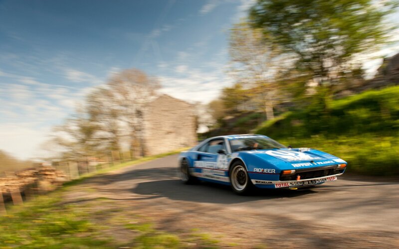 Blue rally car on a winding road