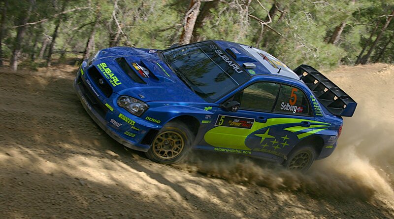 blue rally car on dirt road