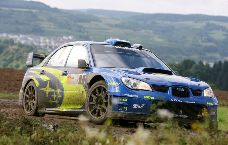blue rally car on dirt road