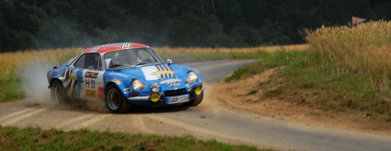 Blue rally car on dirt road