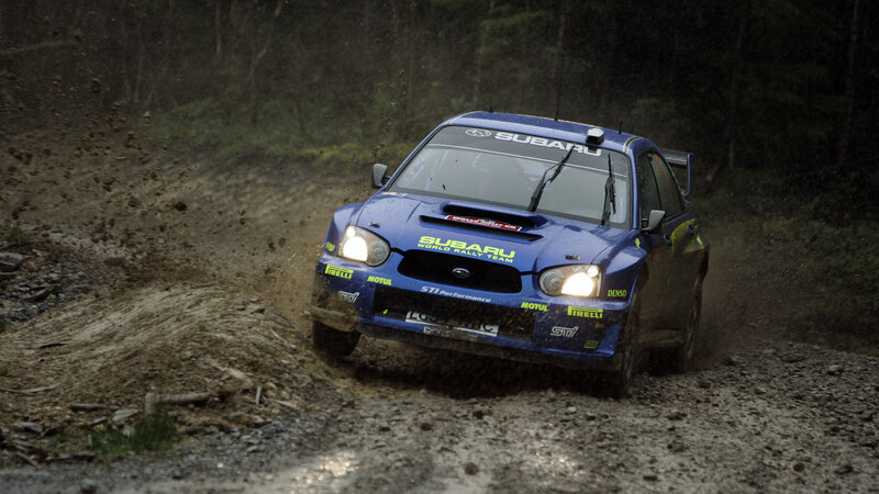blue rally car on dirt road