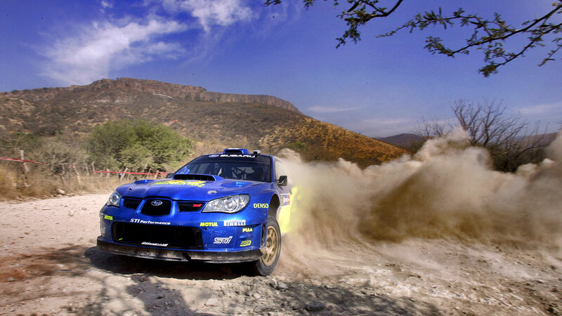 Blue rally car on dirt road