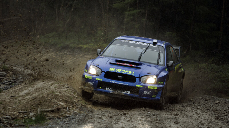 Blue rally car on dirt road