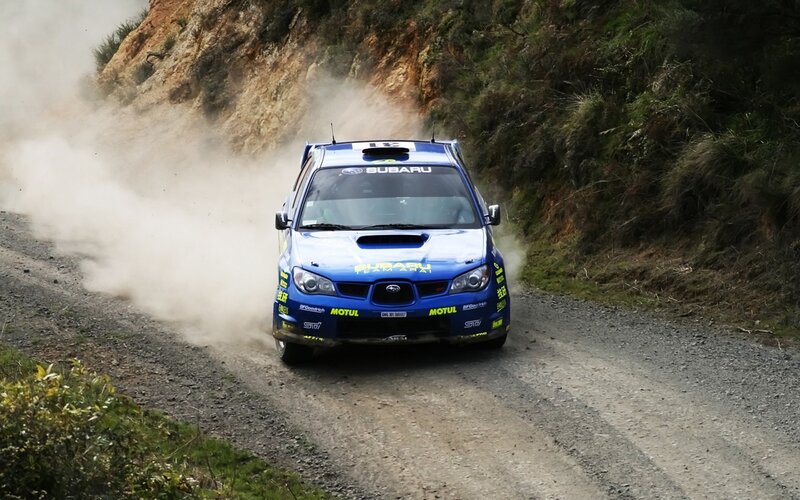 blue rally car on dirt road
