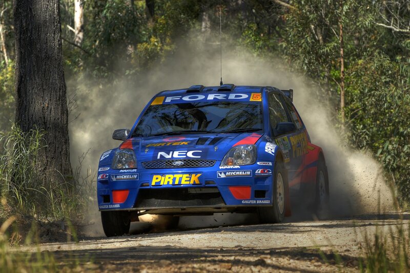 Blue rally car on dirt road