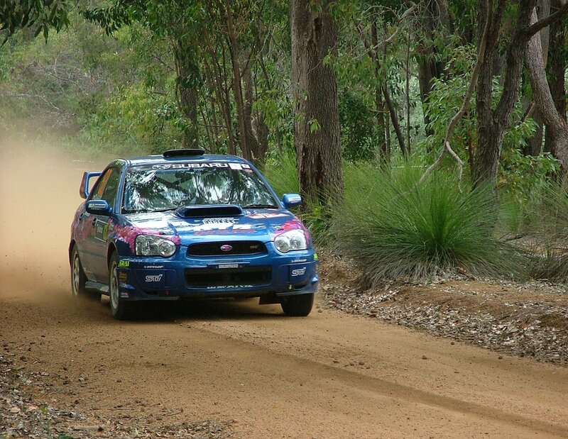 blue rally car on dirt road