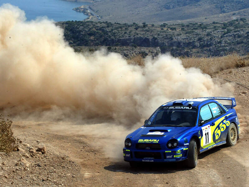Blue rally car on dirt road