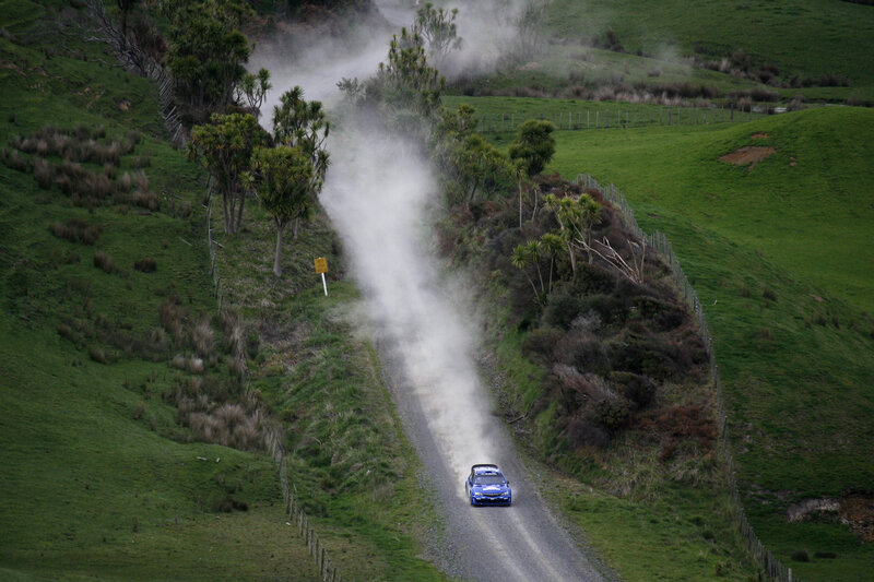 Blue rally car on dirt road