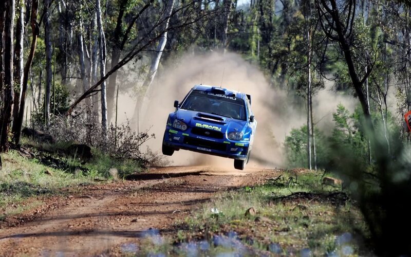 Blue rally car on dirt road