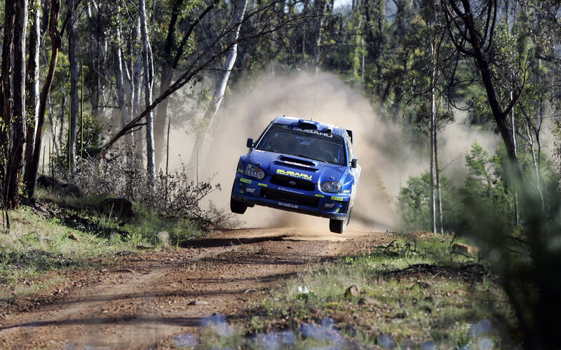 Blue rally car on dirt road