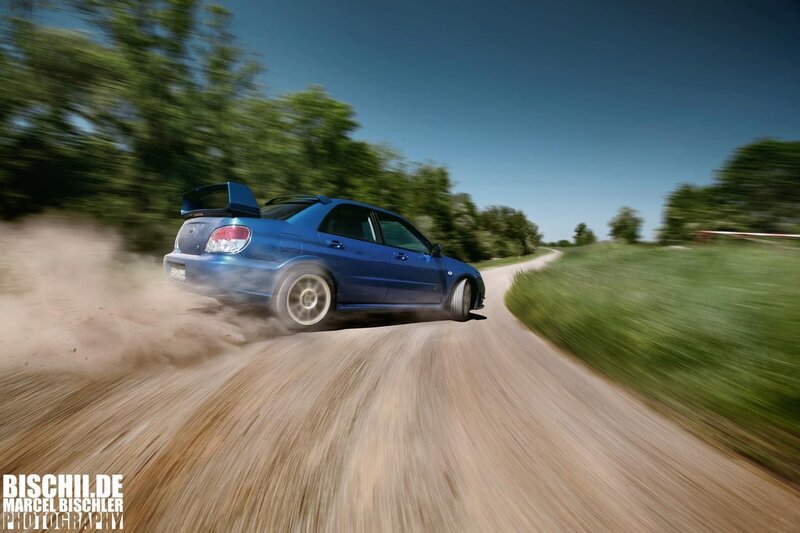 Blue rally car on dirt road