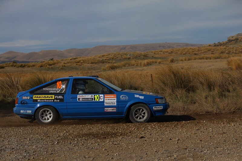 Blue rally car on dirt road