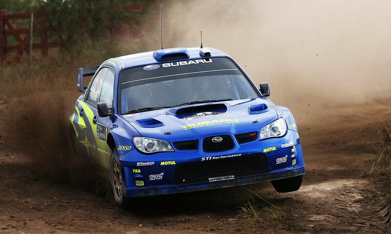 blue rally car on dirt track