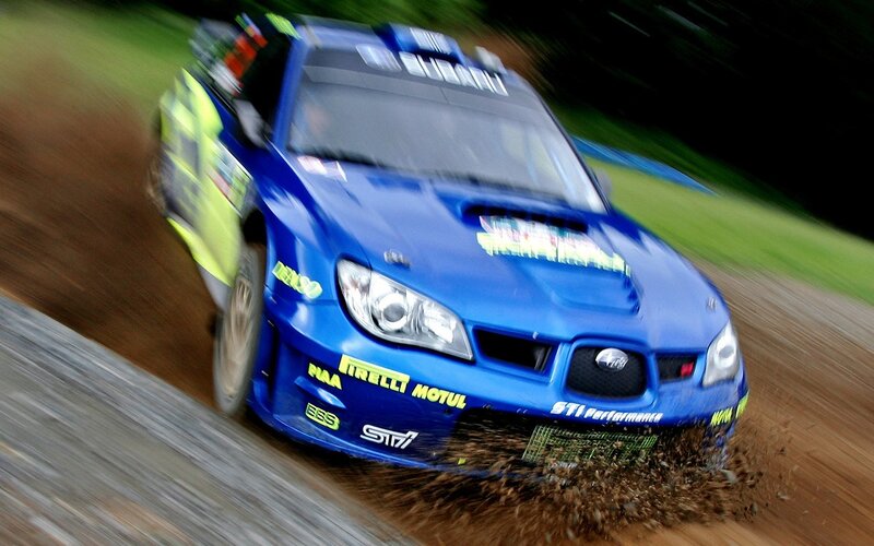 blue rally car on dirt track