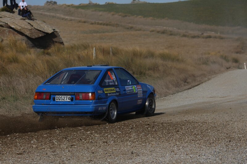 Blue rally car on gravel road
