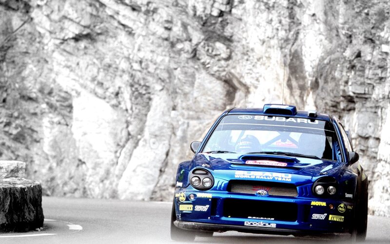 blue rally car on mountain road