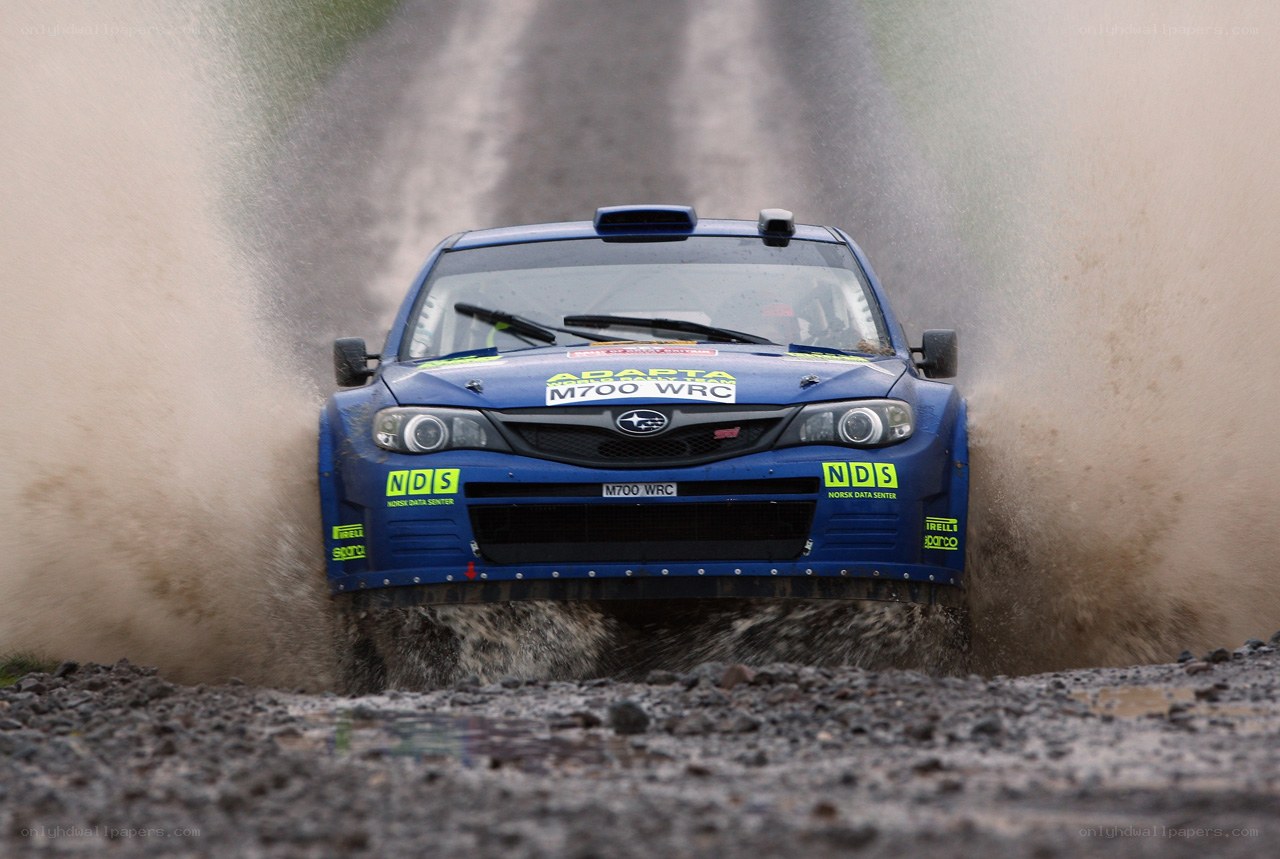 Blue rally car splashing mud