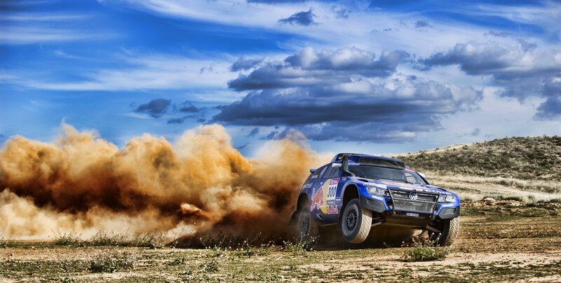 Blue rally truck kicking up dust