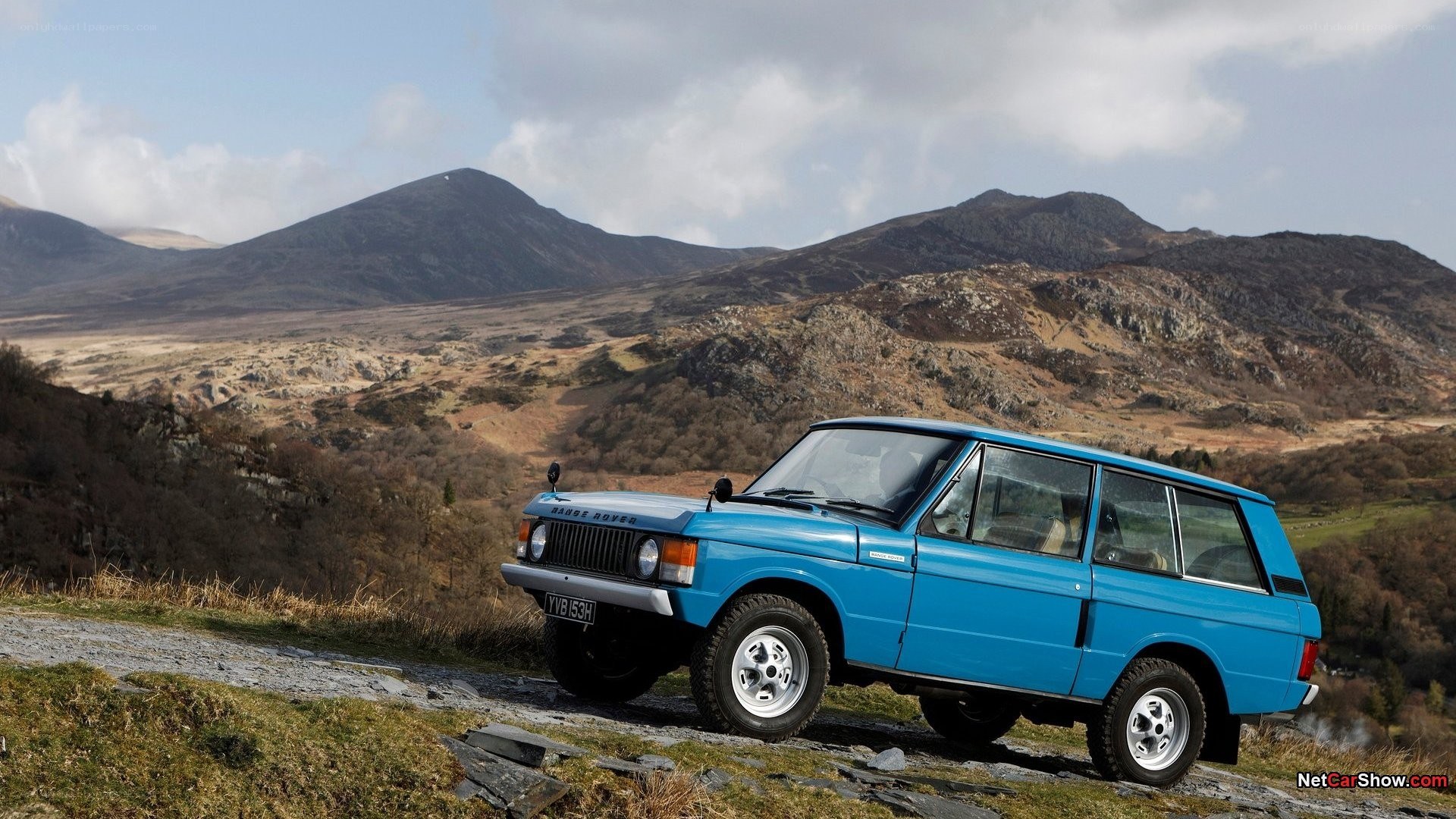 Blue Range Rover in mountain landscape