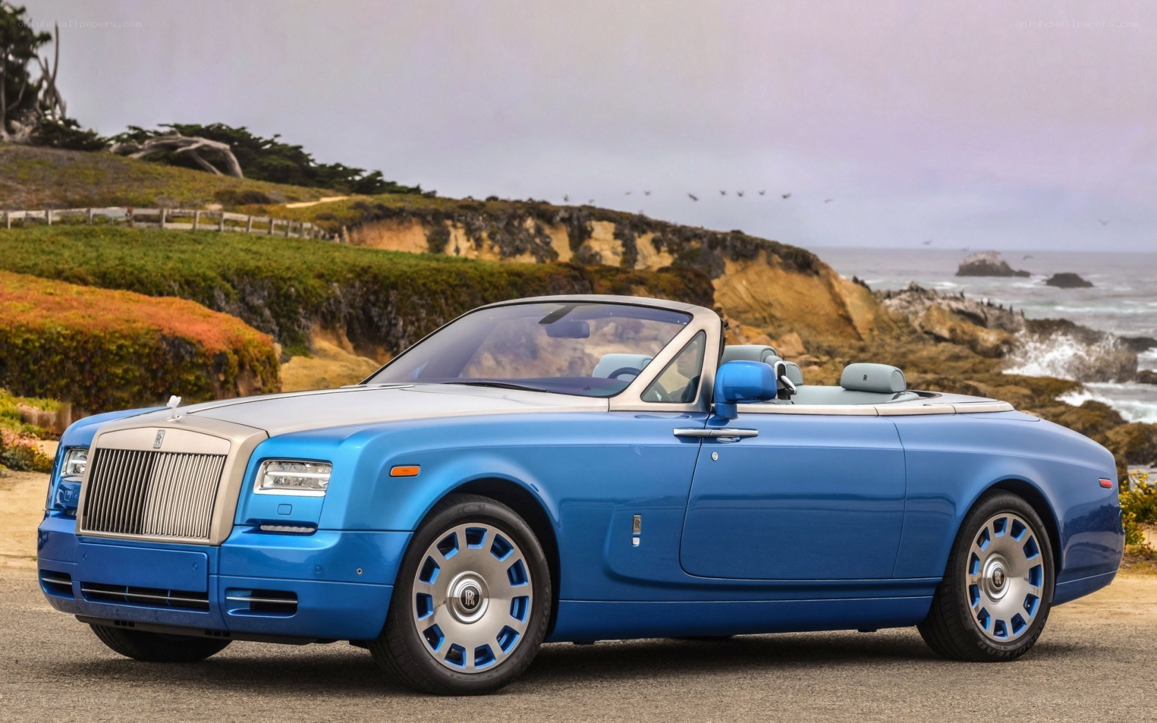 Blue Rolls-Royce convertible by coast