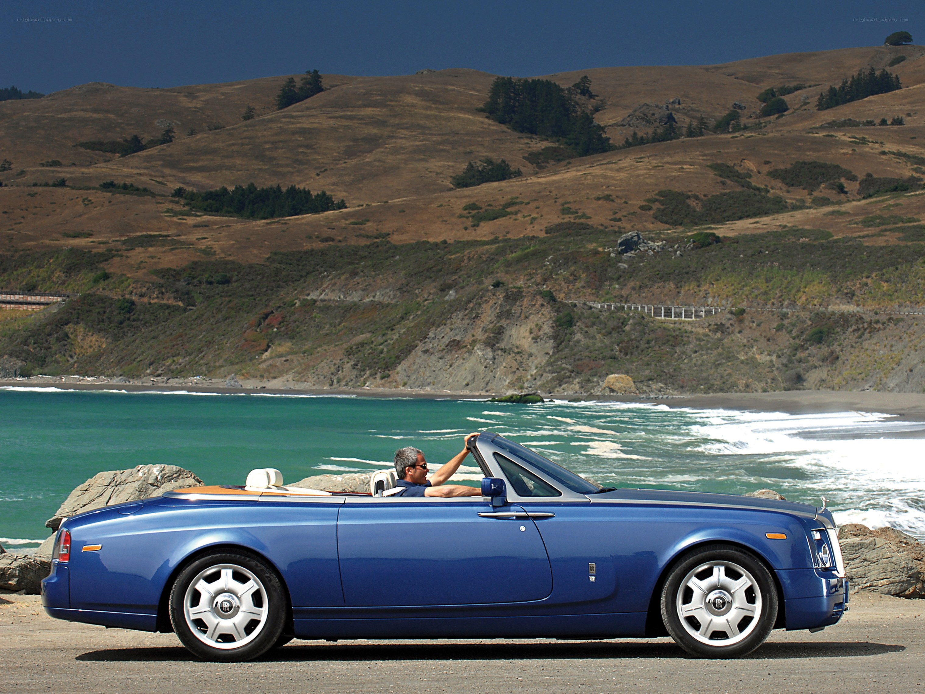 Blue Rolls-Royce convertible by the coast