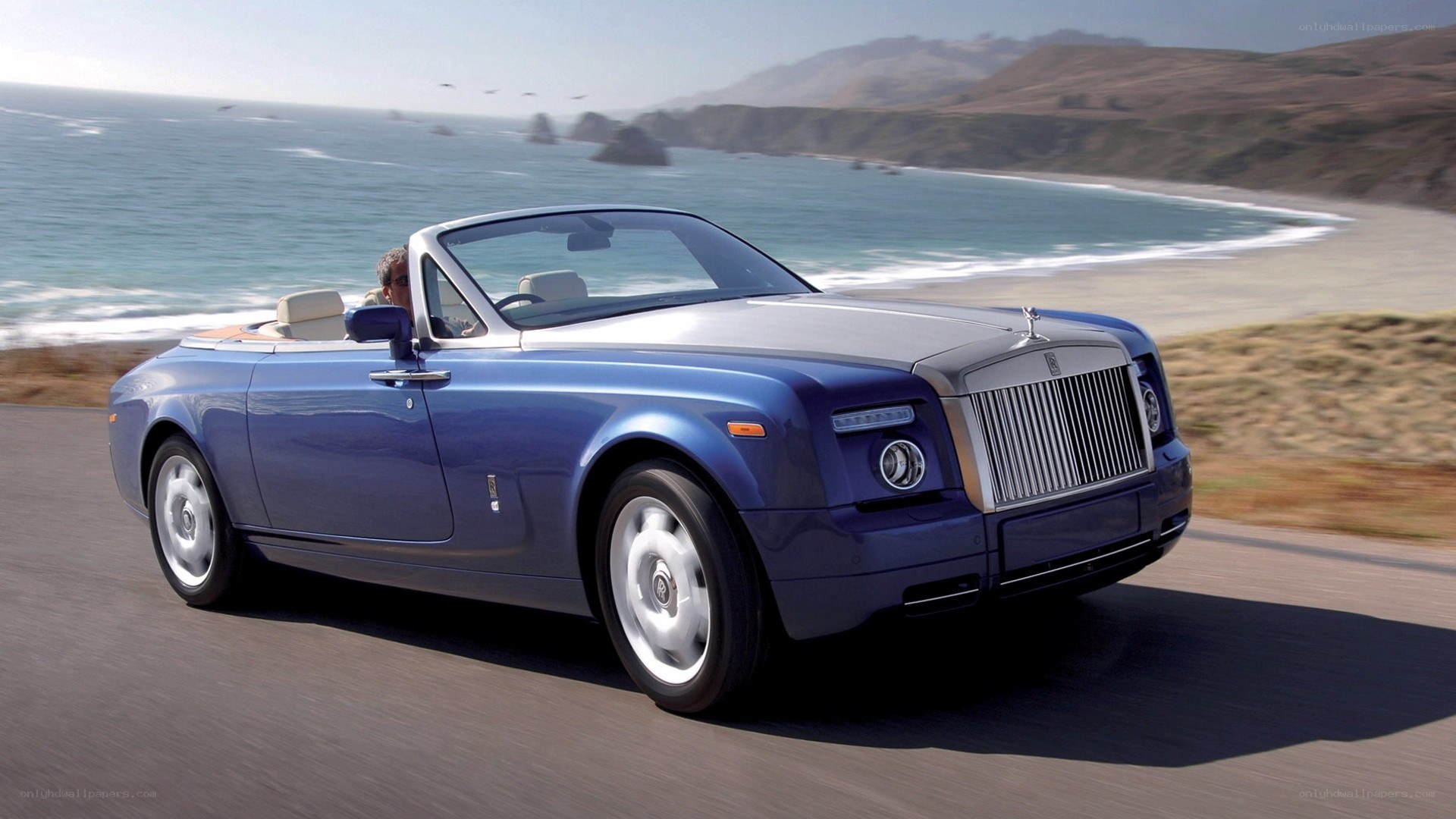 Blue Rolls-Royce convertible on coast