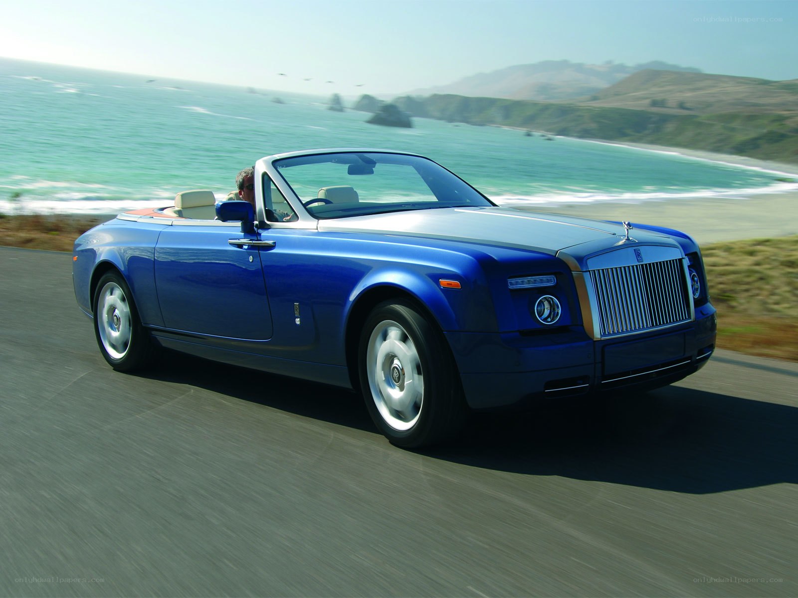 Blue Rolls-Royce convertible on coast