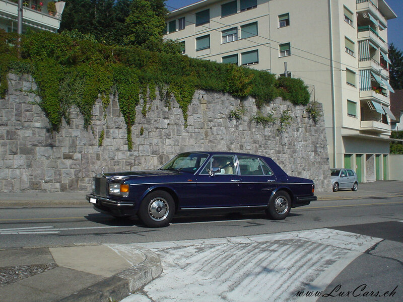 blue rolls-royce on city street
