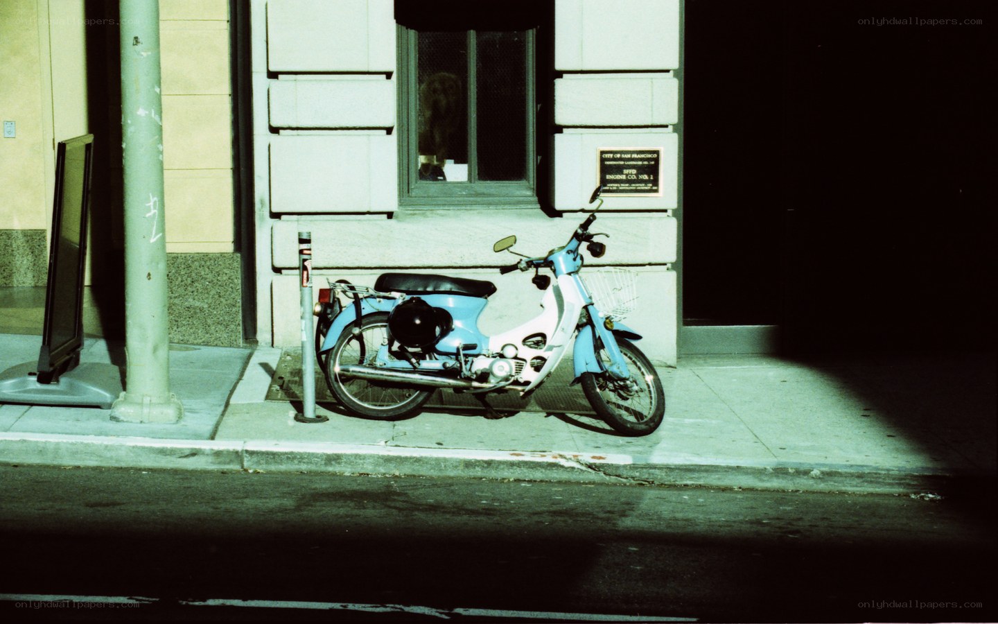 Blue scooter on sidewalk at night