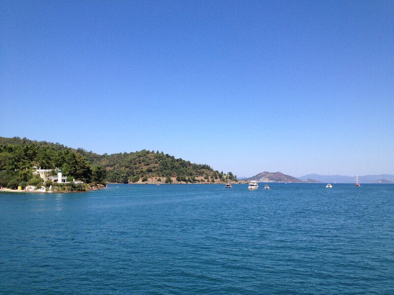 Blue sea with boats and hills