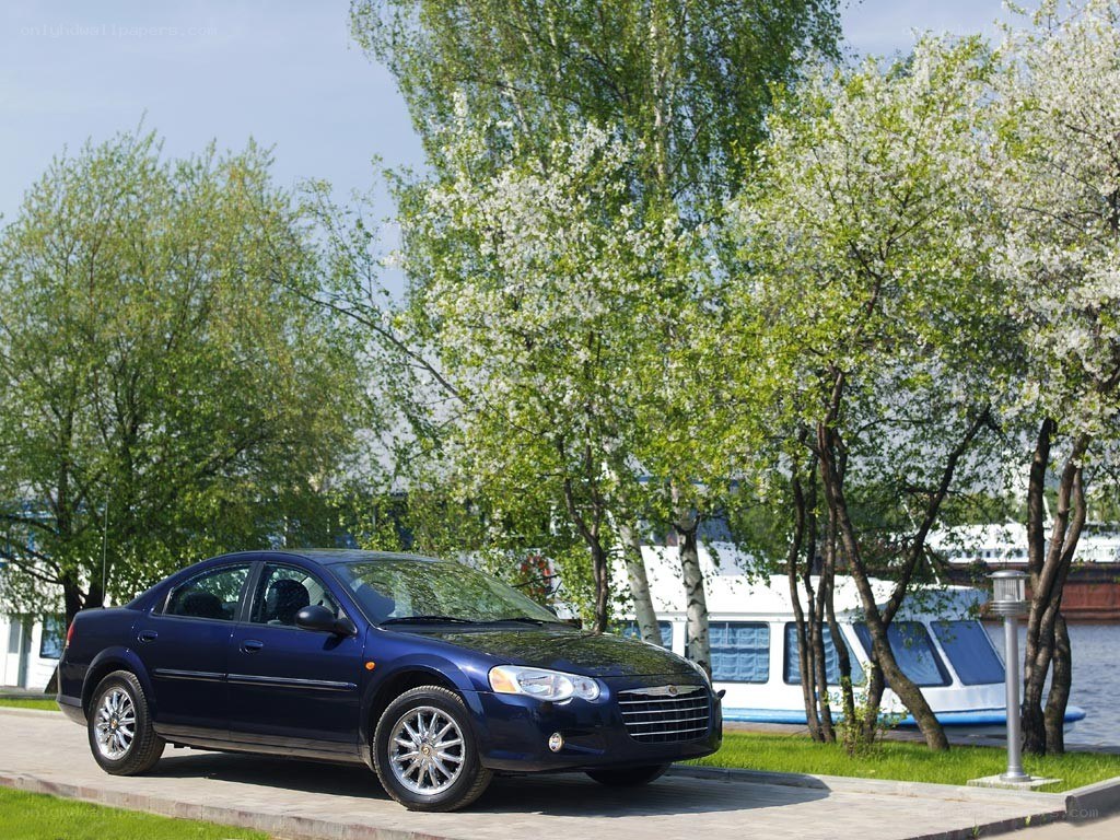 Blue sedan by riverbank